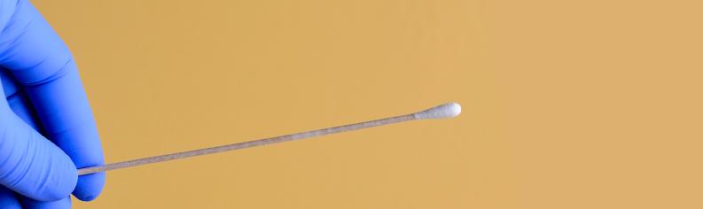 Ein Arzt hält ein Wattestäbchen hoch