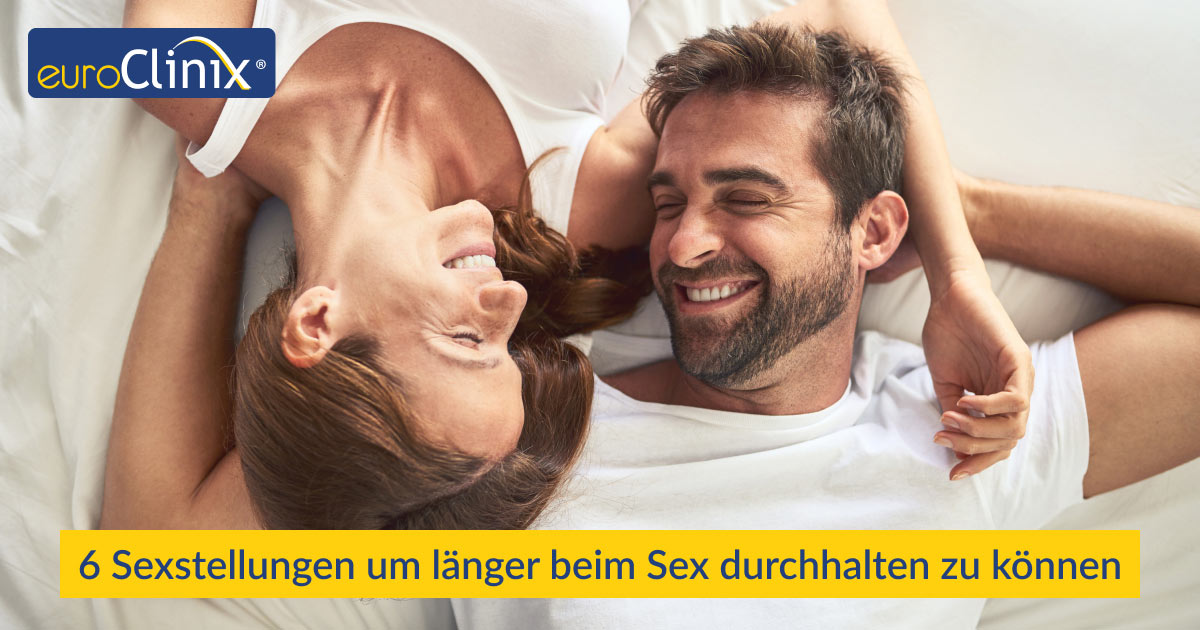 Mann und Frau lächeln sich im Bett liegend an.