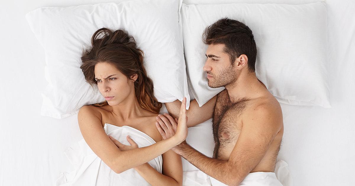  Frau liegt mit Partner im Bett und sagt nein zu Sex. 