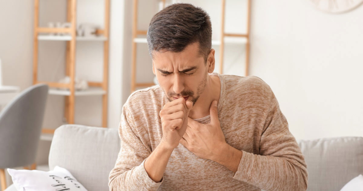 image of a young man coughing