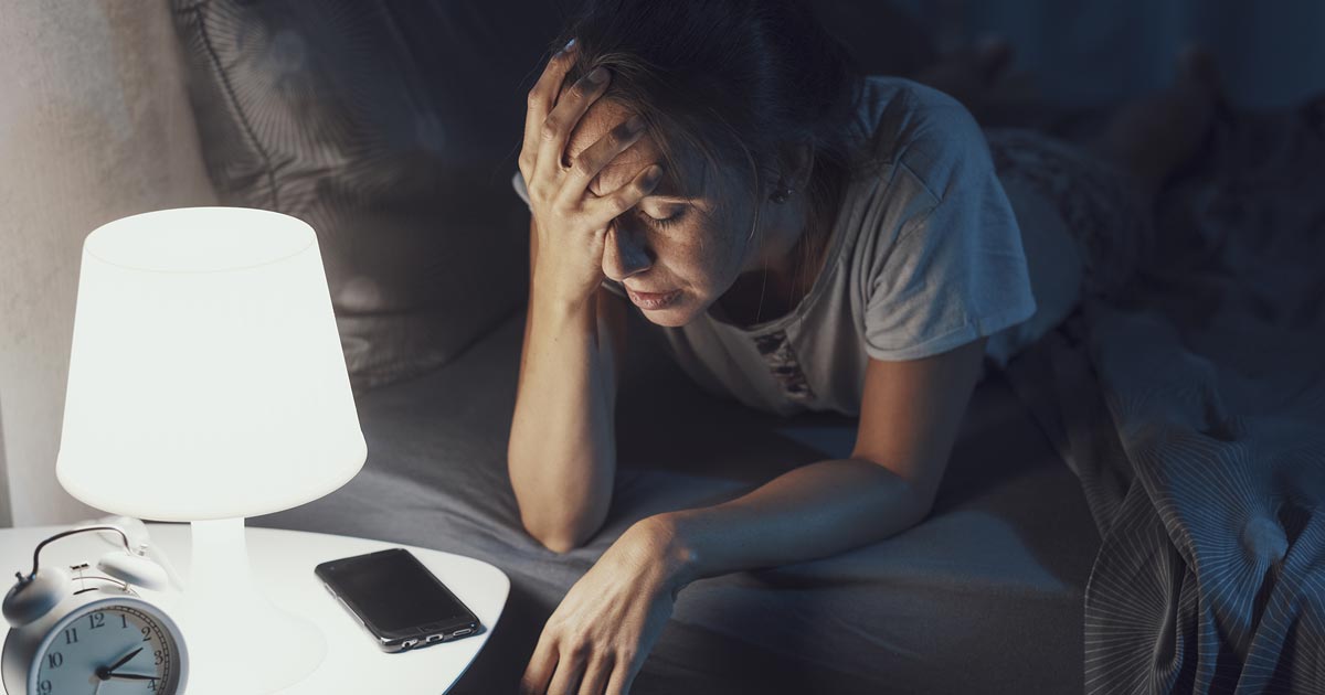 Woman up late at night because she can’t sleep looking stressed.