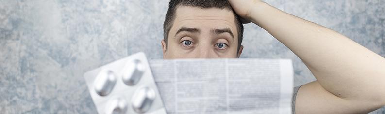  Man confused reading patient information leaflet.