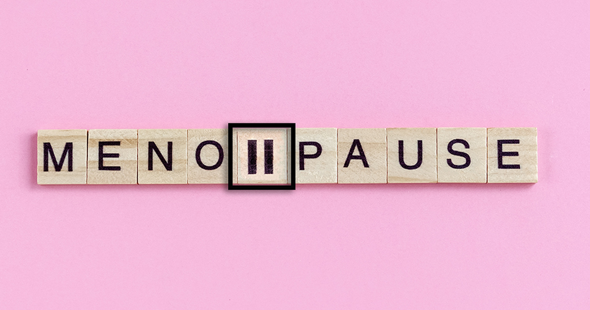 Wooden blocks displaying the word menopause on pink background.
