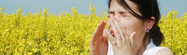 Girl sneezing in a field of flowers