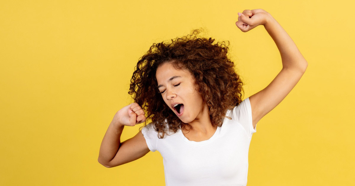 Image of a woman yawning and stretching