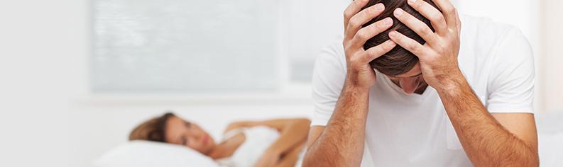 Man sad on bed next to woman on the bed