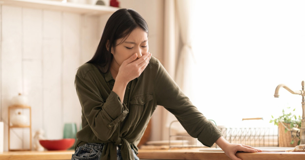 Image of a nauseous woman covering her mouth