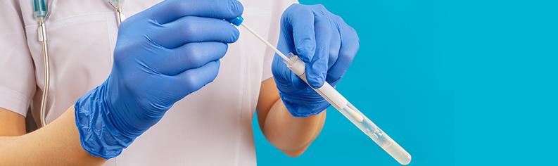 Naishoitaja pitelee käsissään vanupuikkoa ja koeputkea