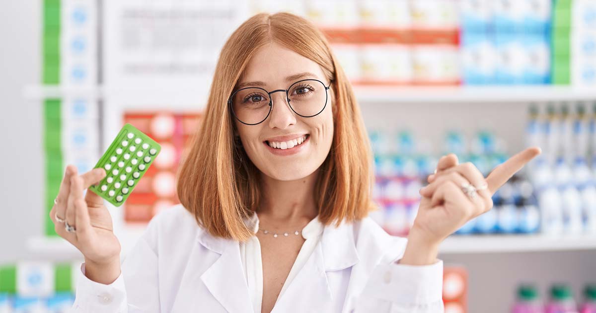 Nuori apteekkityöntekijä käsissään ehkäisypilleripakkaus