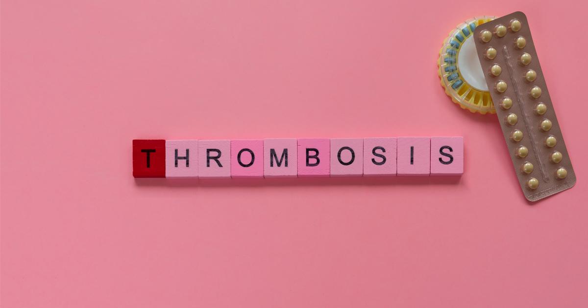 Plaquette contraceptive et pilulier dans le coin supérieur droit avec des blocs de scrabble épelant thrombose sur un fond rose