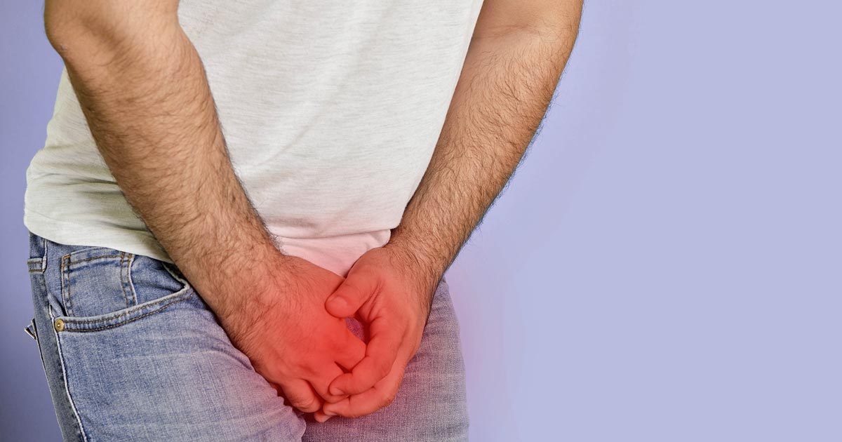 En mann som holder lysken i smerte