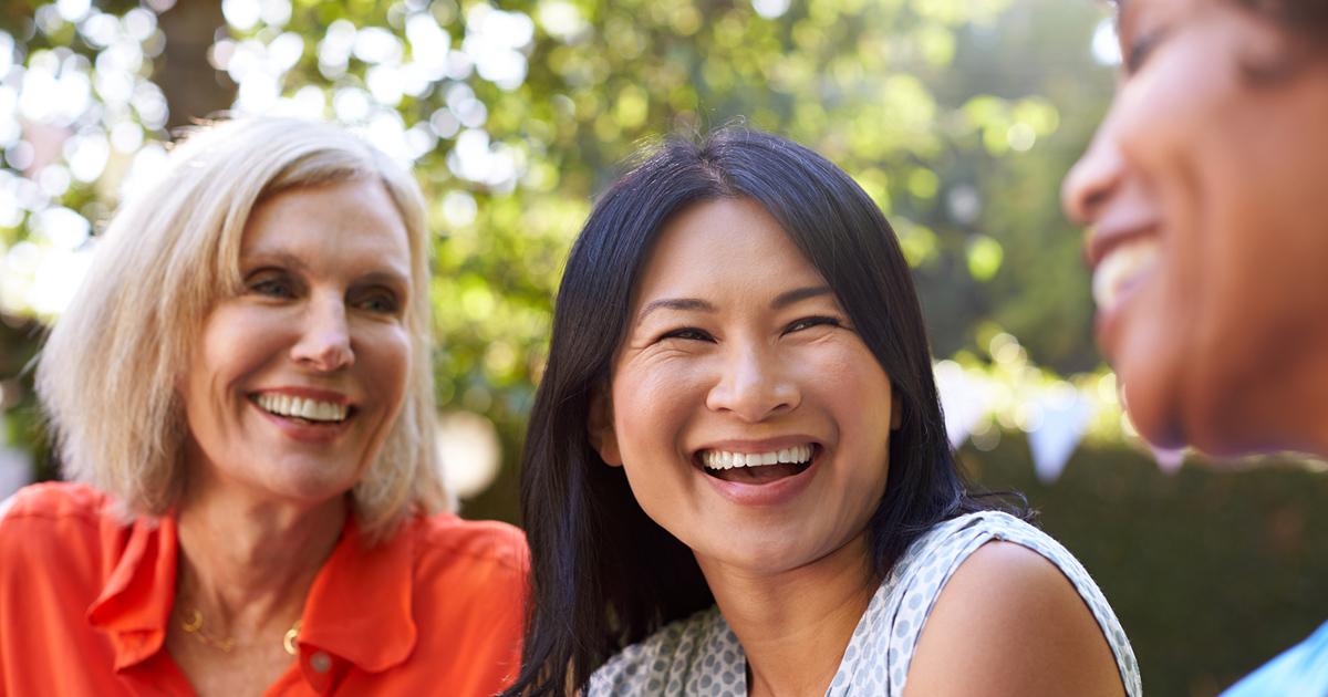 Middelaldrende kvinner som chatter og ler sammen.