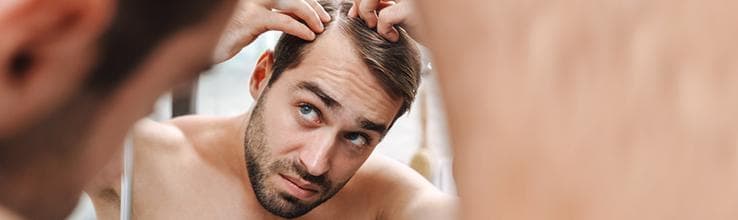 Mężczyzna zauważający objawy łysienia