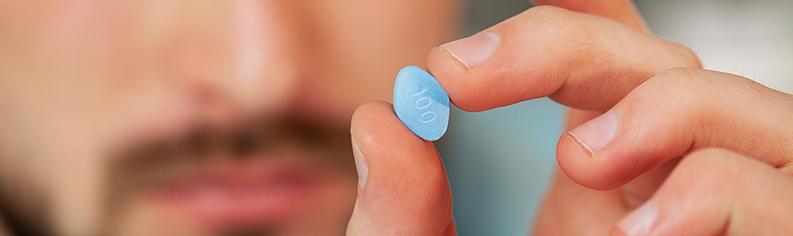 Zbliżenie na lekarza trzymającego pigułkę na potencję dla mężczyzn