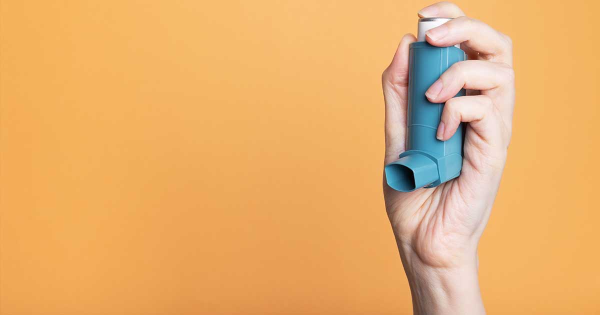 Hand som håller en inhalator
