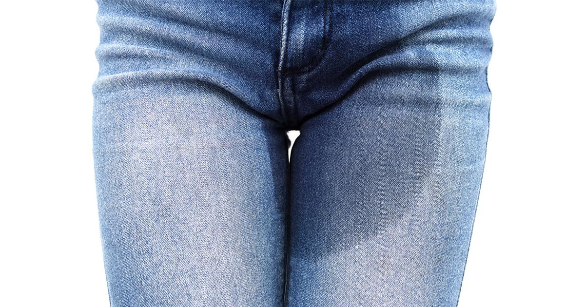 Närbild på en kvinnas jeans med en urinfläck.