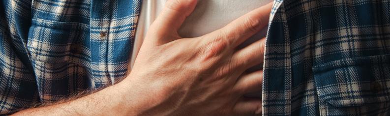 Närbild av mannen som håller i bröstet som lider av halsbränna