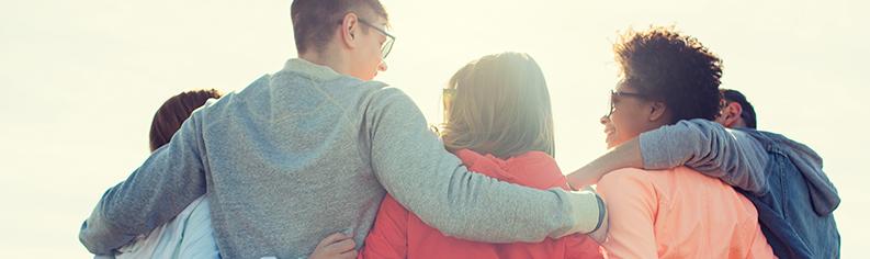 Människor med ryggen vänd med armarna runt varandras axlar